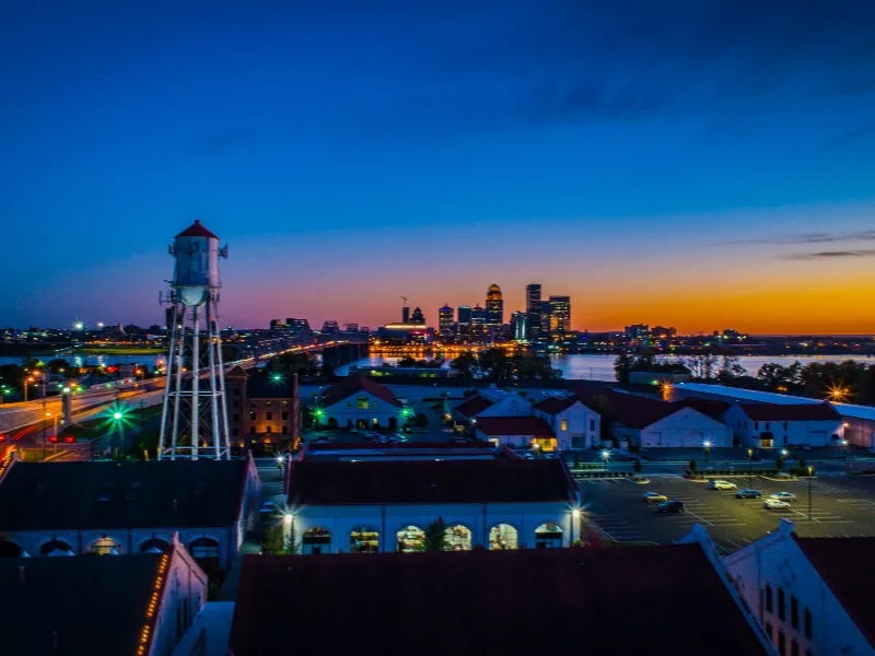 City skyline at sunset with a water tower and buildings in the foreground.